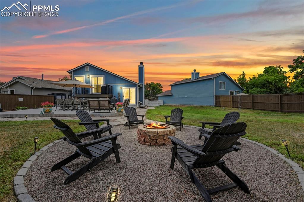Caption: Patio terrace at dusk with an outdoor fire pit, a patio, and a deck