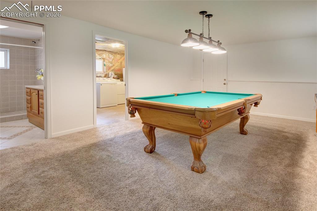Image 20 of 27: Spacious room with plush carpeting, featuring a wood-finish billiards table