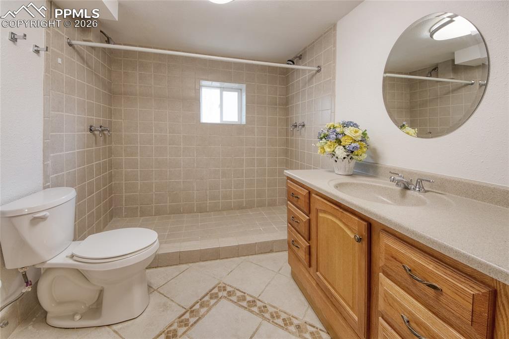 Image 22 of 27: Tiled shower stall with two shower heads and window