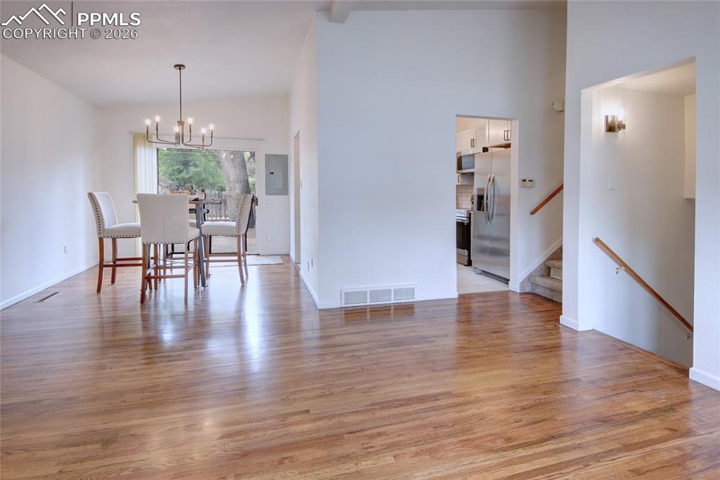 Image 4 of 27: Expansive wood-finish flooring extends through the main living area