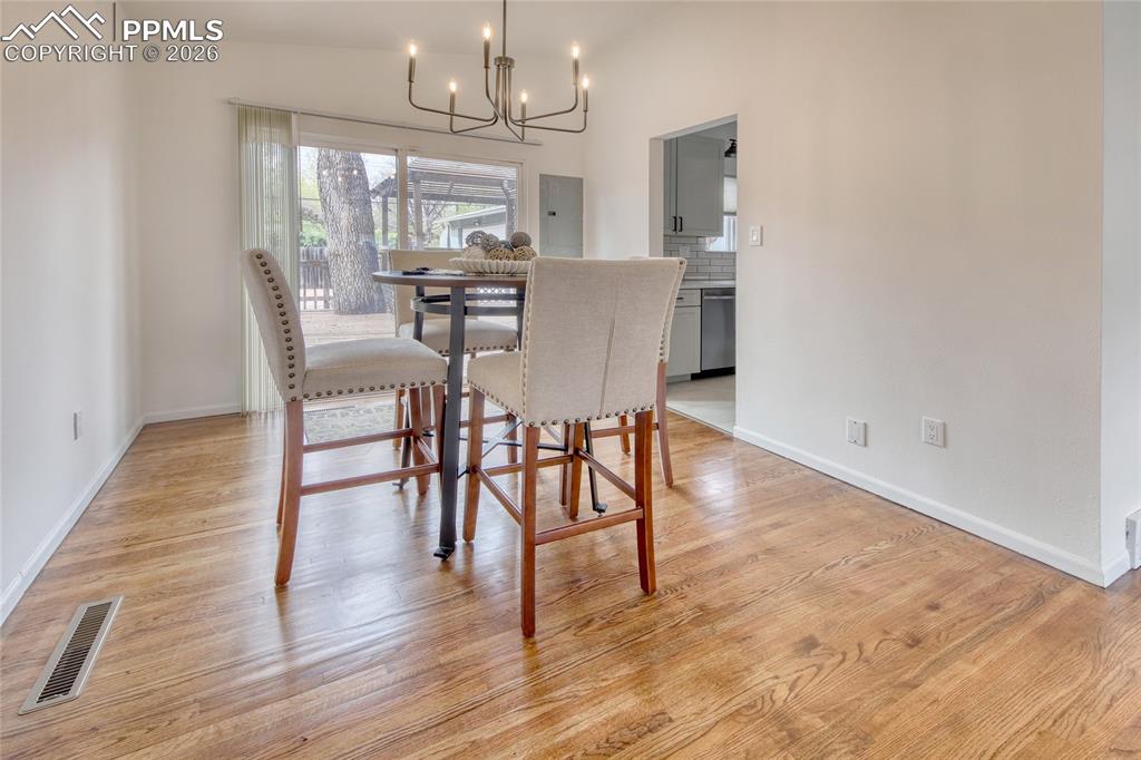 Image 5 of 27: Dining area featuring wood-finish flooring, white baseboards, a modern blac