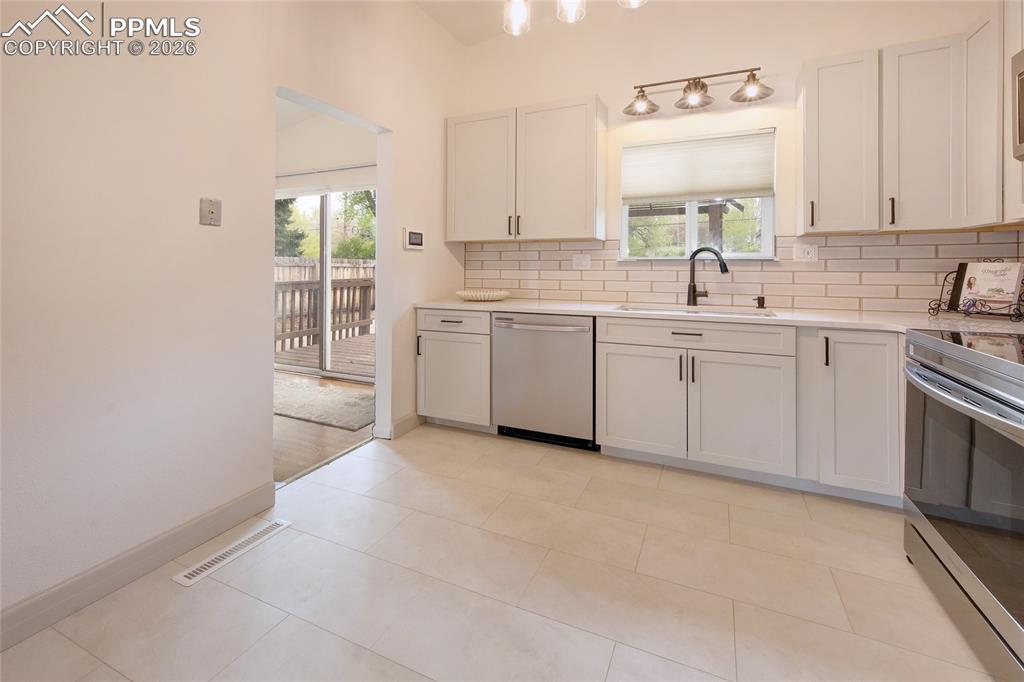 Image 9 of 27: Contemporary kitchen featuring light cabinetry, stainless steel appliances,