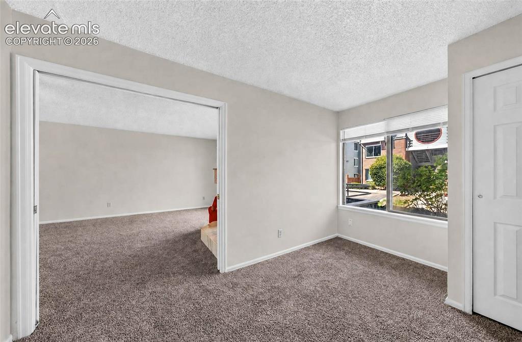 Image 13 of 22: Neutral wall paint, carpet flooring, windows with horizontal blinds, built-