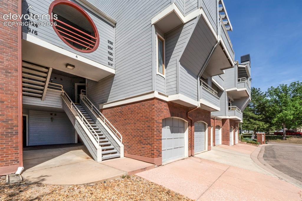 Image 21 of 22: Building exterior featuring brick facade, horizontal siding, multiple balco