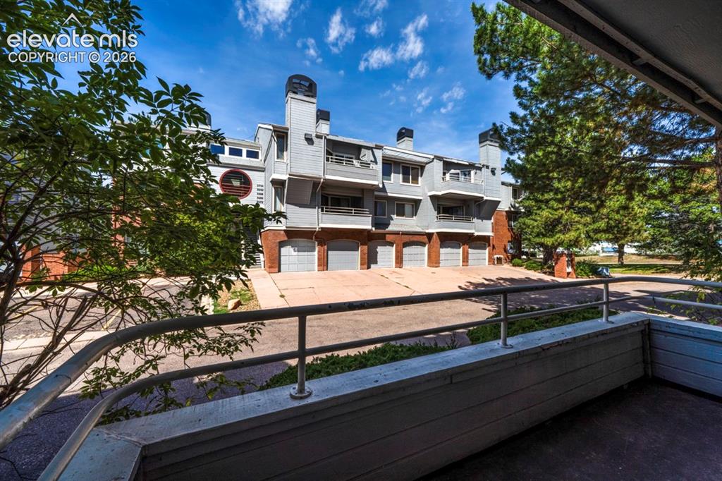 Image 8 of 22: Multi-story building featuring a gray facade and multiple attached garages