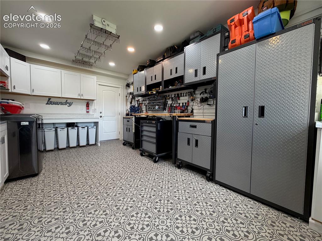Image 25 of 50: In addition to laundry this room was also a tool room. Cabinets and tools