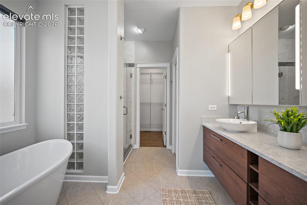 Image 32 of 50: Modern tub.  Window has electric shade