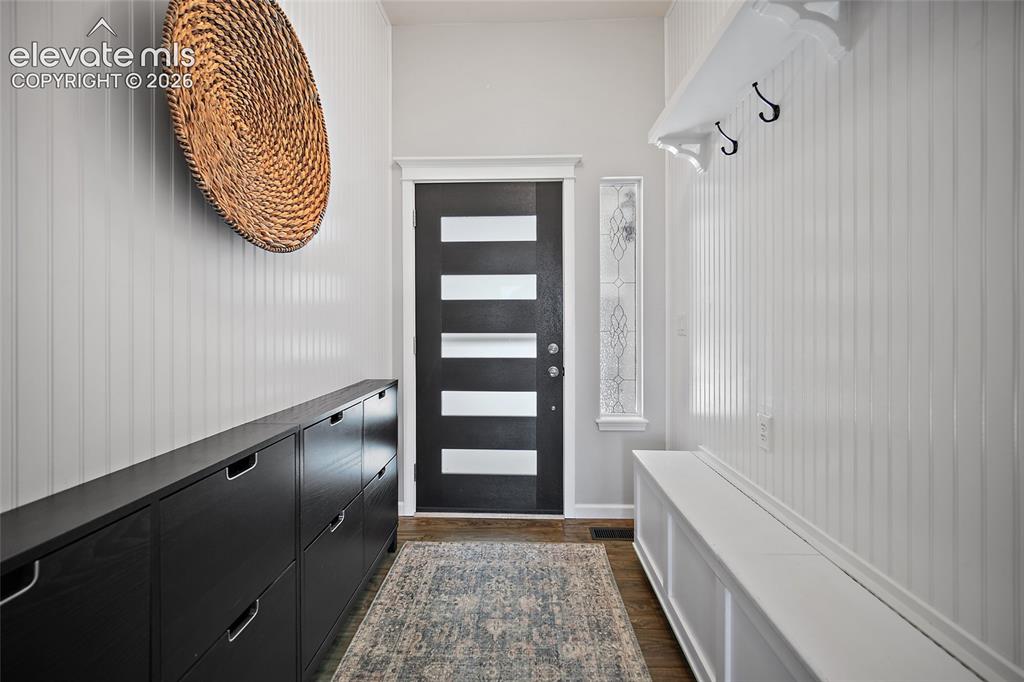 Image 4 of 50: Foyer with built in cabinets, bench & coat hooks