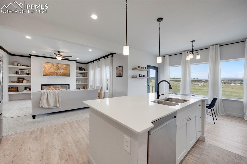 Image 11 of 37: Kitchen featuring white cabinetry, a glass covered fireplace, decorative li