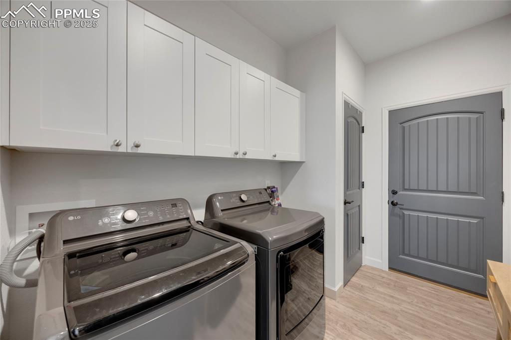Image 18 of 37: Washroom featuring light wood finished floors, cabinet space, and independe