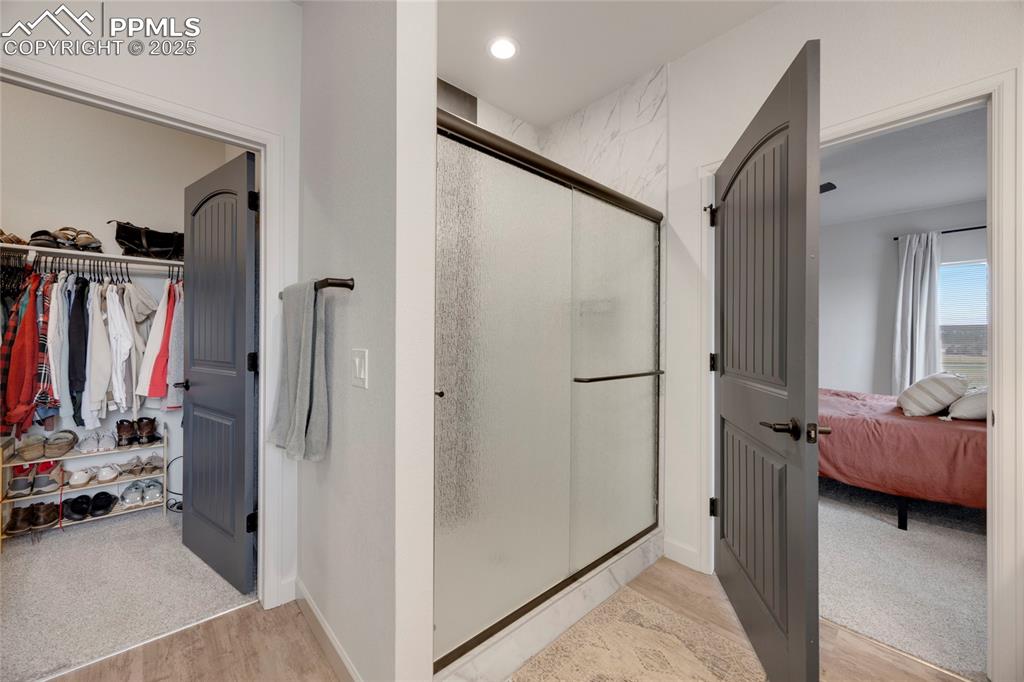 Image 22 of 37: Full bath featuring a shower stall, light wood finished floors, a spacious
