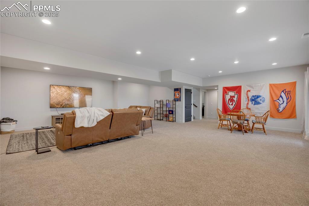 Image 23 of 37: Living area with recessed lighting and carpet flooring