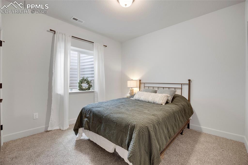 Image 30 of 37: Bedroom with light colored carpet
