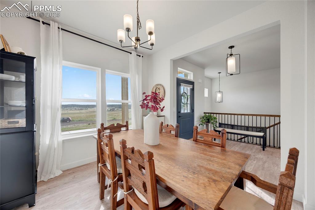 Image 8 of 37: Dining area with light wood-style flooring and a chandelier