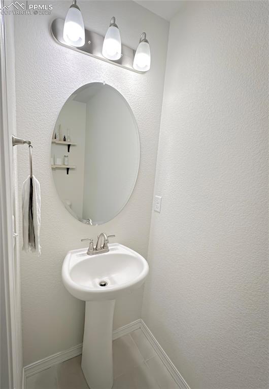Image 12 of 42: Bathroom featuring a textured wall and tile patterned floors