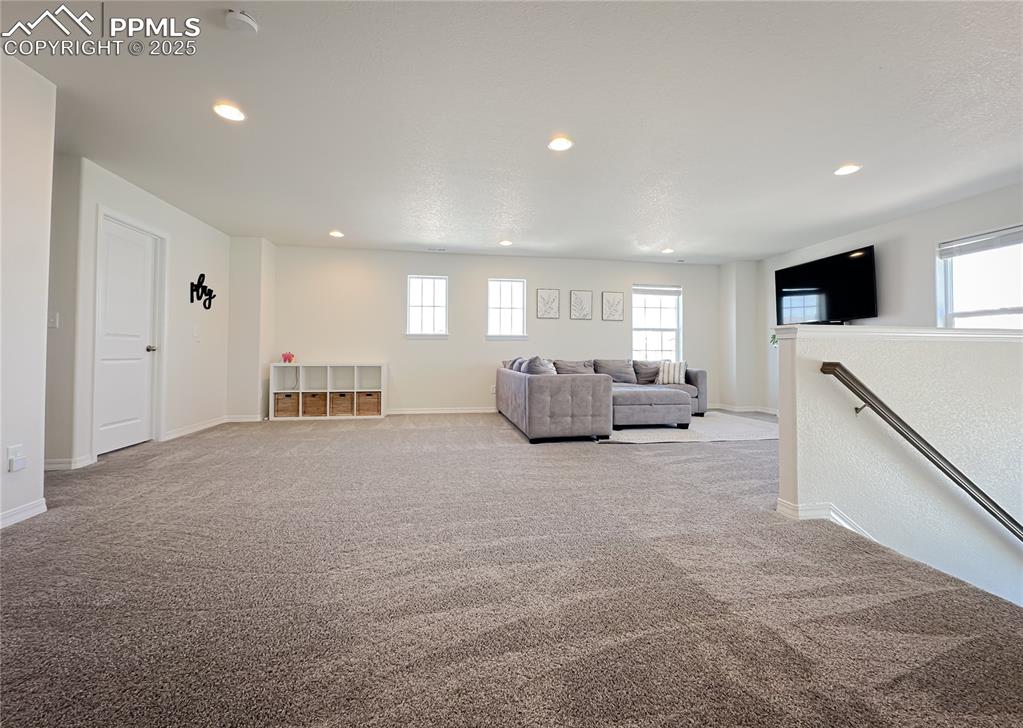 Image 20 of 42: Living room featuring light carpet, plenty of natural light, and recessed l