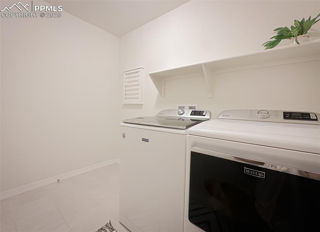 Image 23 of 42: Washroom featuring separate washer and dryer and light tile patterned floor