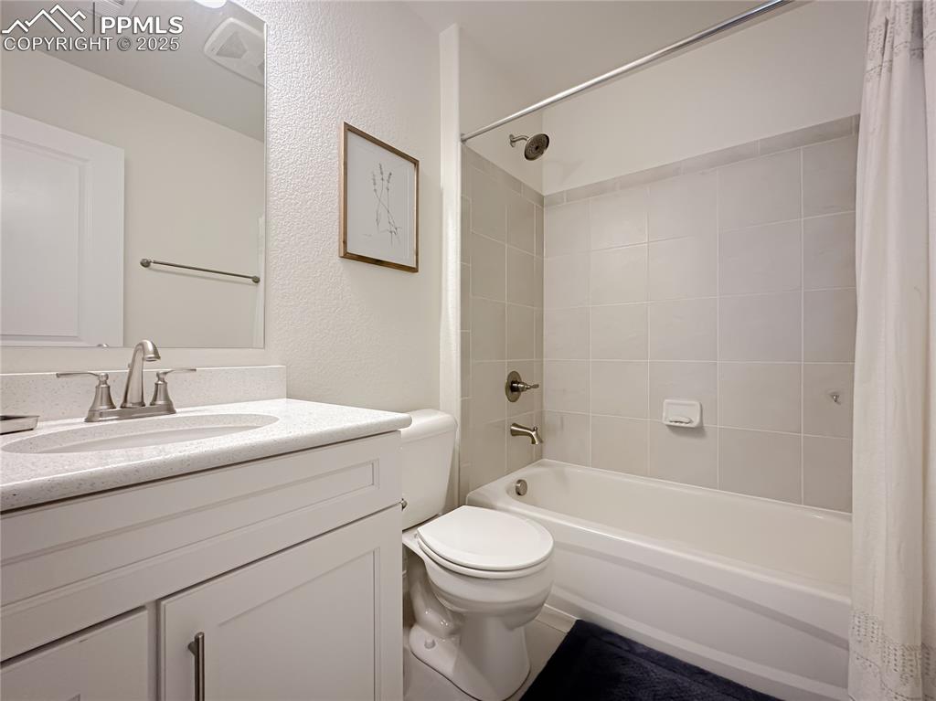 Image 33 of 42: Full bathroom with shower / bath combo with shower curtain, vanity, and a t
