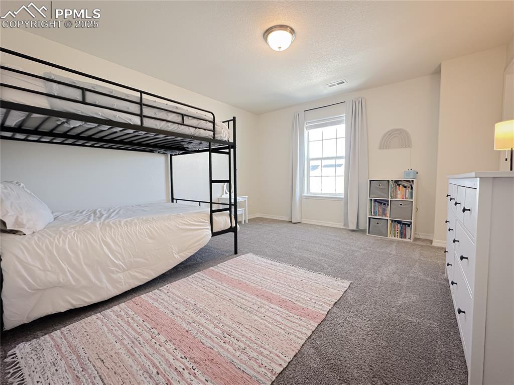 Image 35 of 42: Bedroom featuring light carpet and a textured ceiling