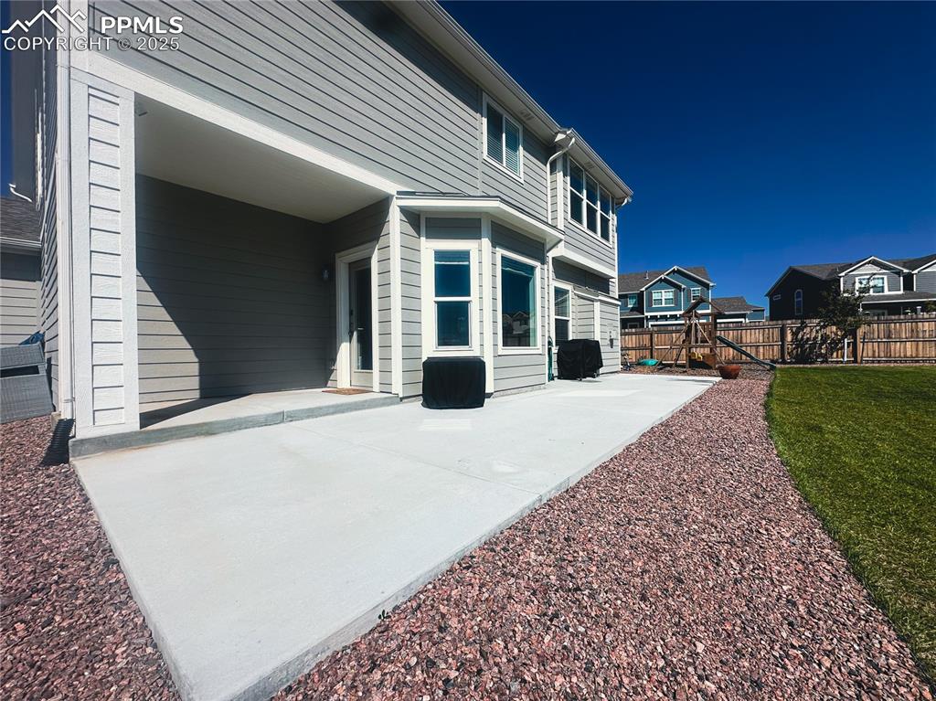 Image 40 of 42: Fenced backyard with a patio