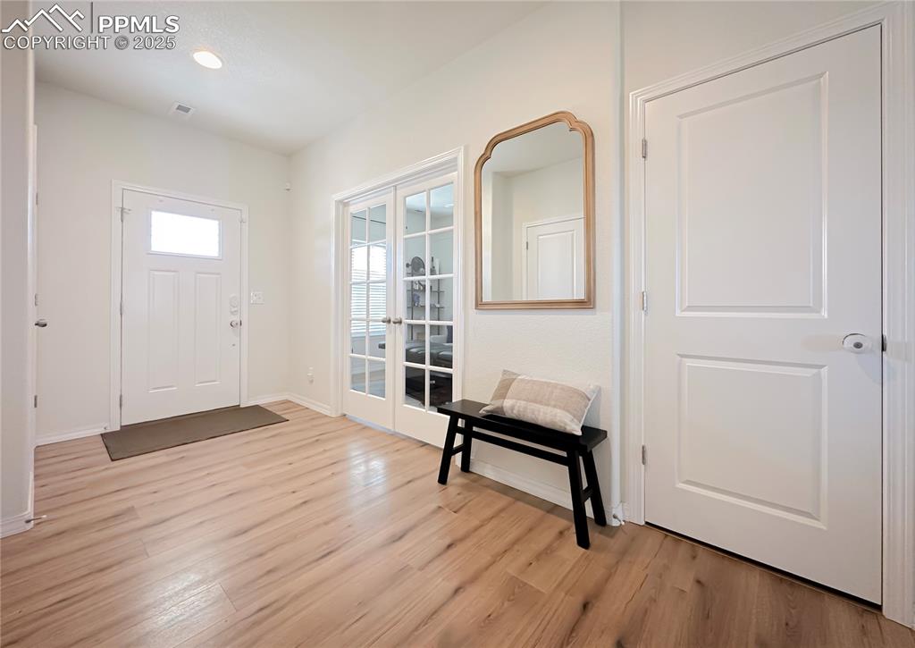 Image 7 of 42: Entryway with french doors, light wood-type flooring, and recessed lighting