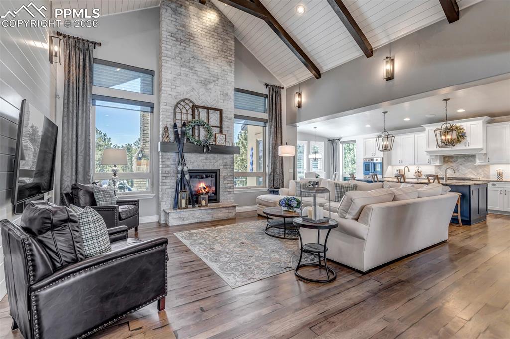 Image 14 of 50: Dining room with a stone fireplace, a chandelier, dark wood-style floors, w