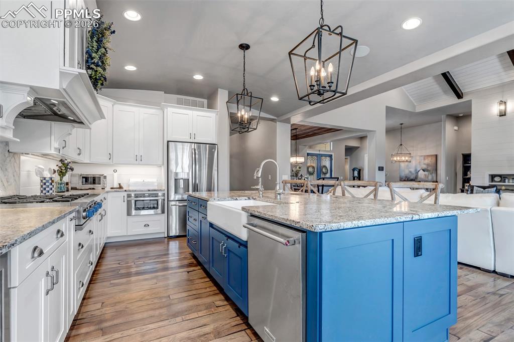 Image 25 of 50: Two tone kitchen featuring two tone cabinetry, wine cooler, light wood-styl