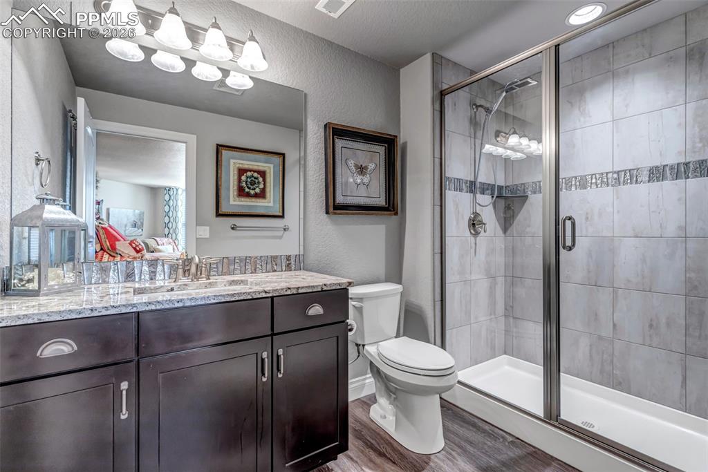 Image 40 of 50: Bedroom with light colored carpet, an office area, and a textured ceiling