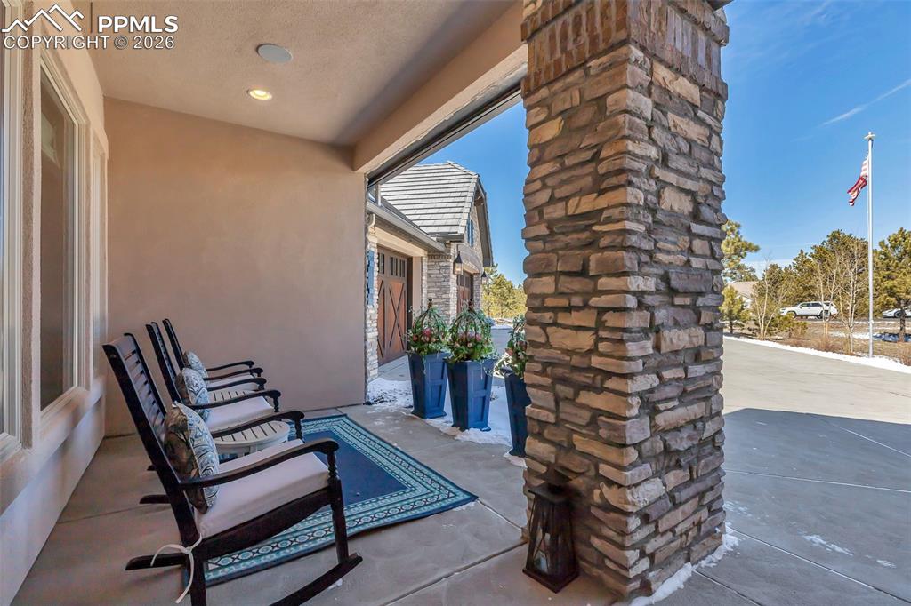 Image 8 of 50: Property entrance with stone siding, a patio area, and french doors