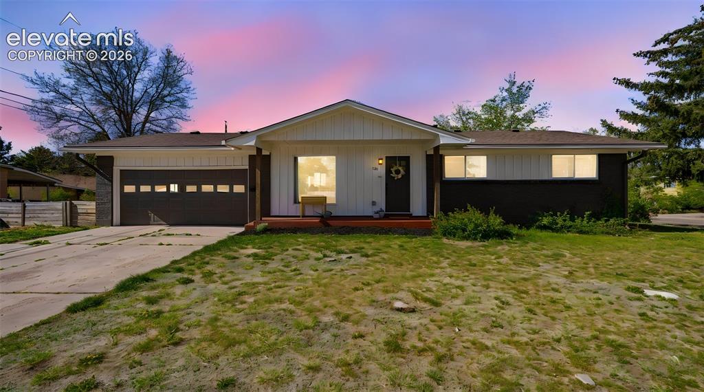 Image 1 of 43: Ranch-style exterior with a dark garage door, white vertical siding, and da