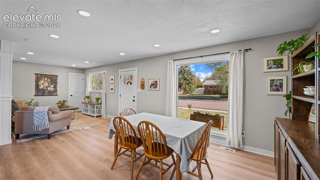 Image 13 of 43: Open-concept dining and living area featuring wood-finish flooring, recesse