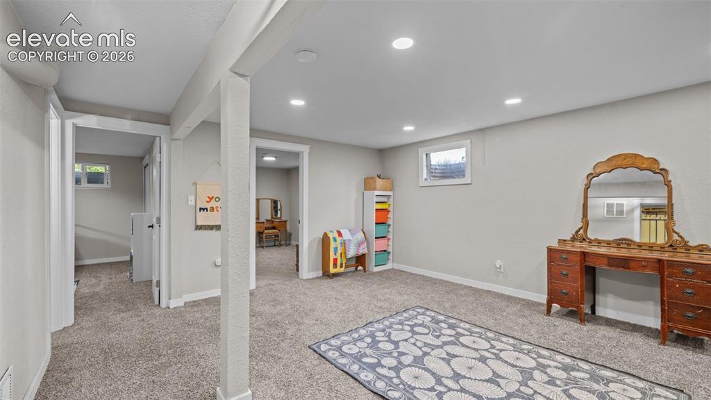 Image 21 of 43: Spacious carpeted room featuring recessed lighting, light gray walls, and a