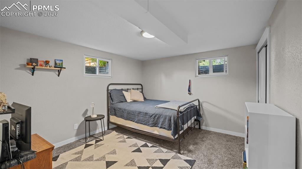 Image 23 of 42: Carpeted room with light gray walls, two windows, and a built-in closet wit