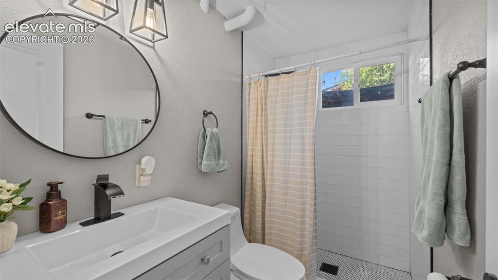 Image 23 of 43: Bathroom vanity featuring a rectangular sink, matte black faucet, and a cir