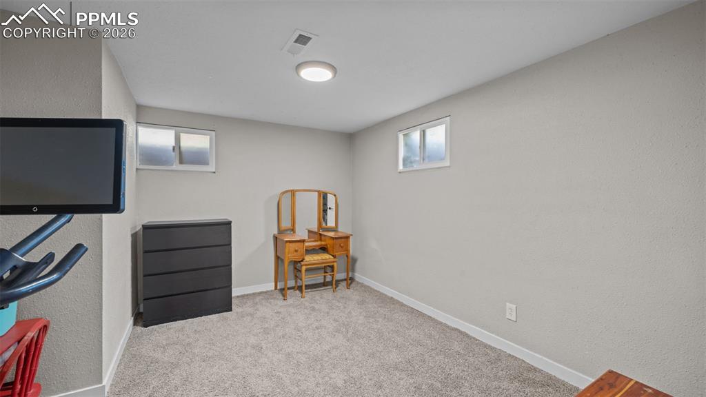 Image 24 of 42: Carpeted interior space featuring light-toned textured walls, white trim, a