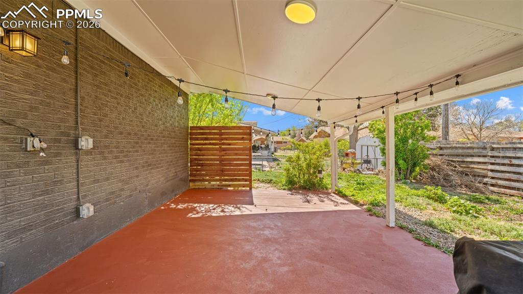 Image 29 of 42: Covered patio featuring a red-toned concrete surface