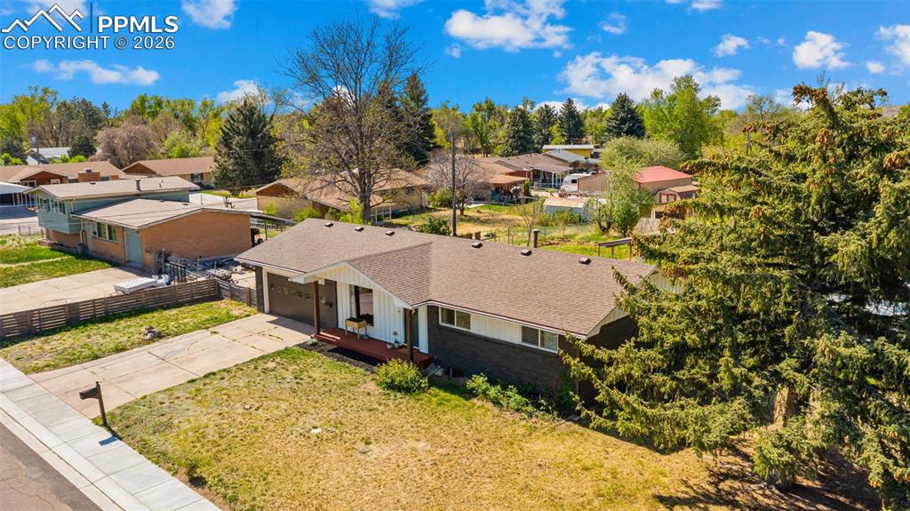 Image 32 of 42: Ranch-style residence featuring a dark facade, white siding accents, and a 