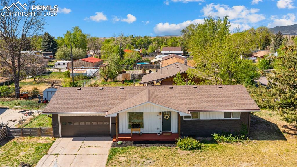 Image 33 of 42: Ranch-style residence featuring a brown shingle roof, attached garage with 