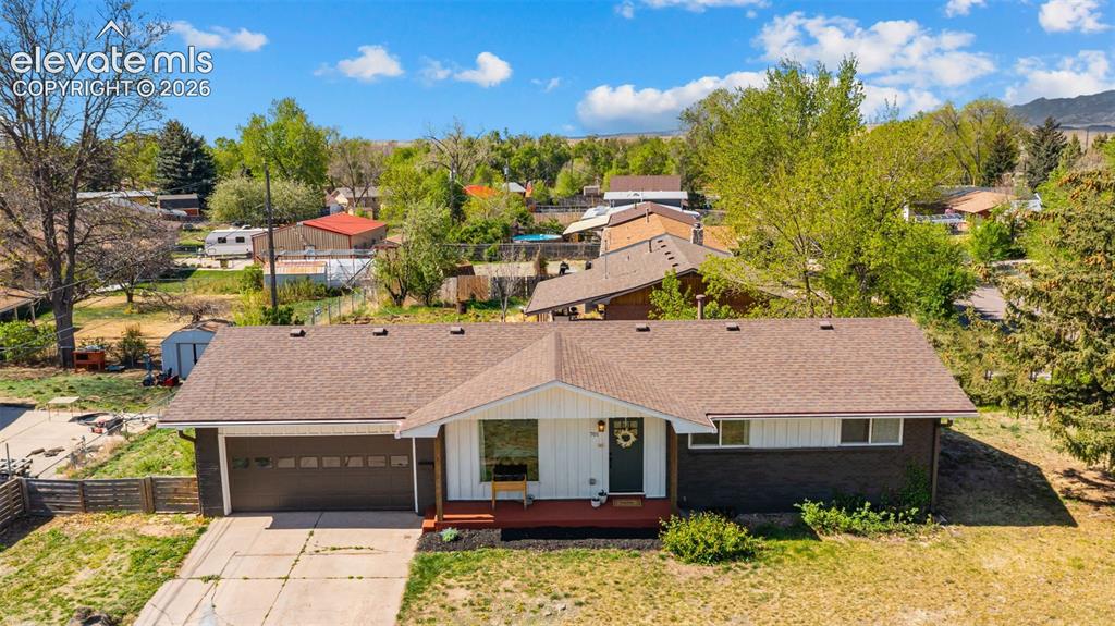Image 34 of 43: Ranch-style residence featuring a brown shingle roof, attached garage with