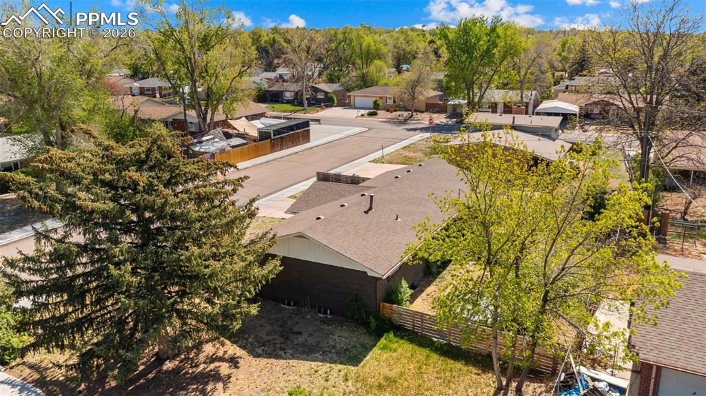 Image 37 of 42: Corner lot with a brown shingle roof and brick exterior