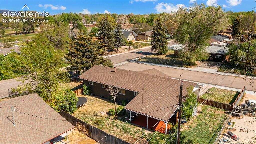 Image 37 of 43: Brown shingle roofing with a covered patio featuring a red-hued deck