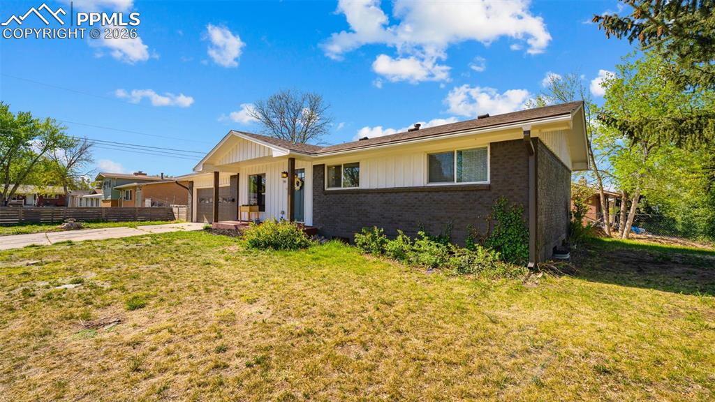 Image 39 of 42: Ranch-style residence featuring a white vertical siding facade and dark bri