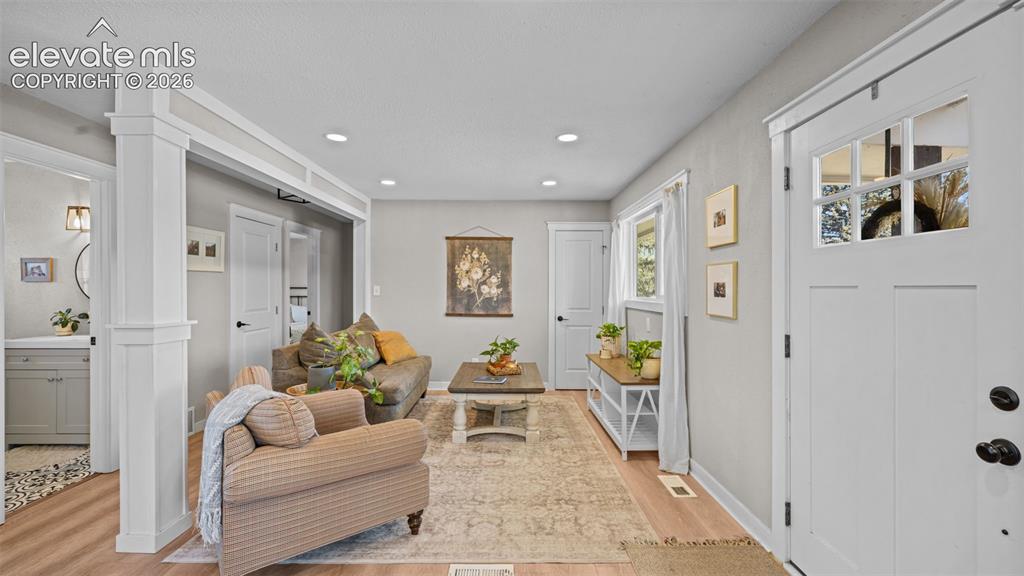 Image 6 of 43: Open-concept living space featuring wood-finish flooring, recessed lighting