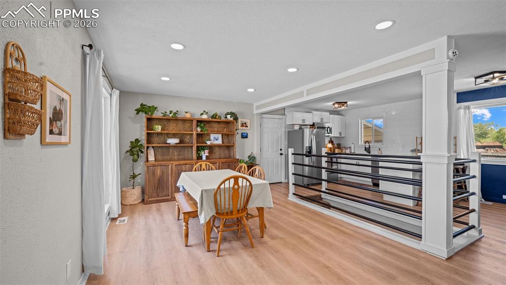 Image 7 of 42: Open-concept living area featuring wood-finish flooring, recessed lighting,