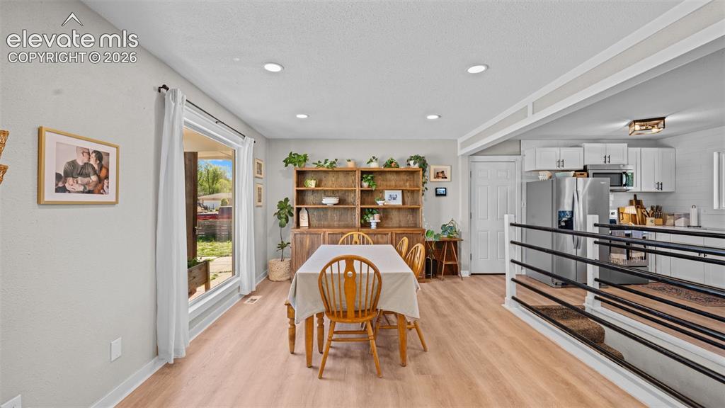 Image 9 of 43: Open-concept living space with wood-finish flooring, recessed lighting, and