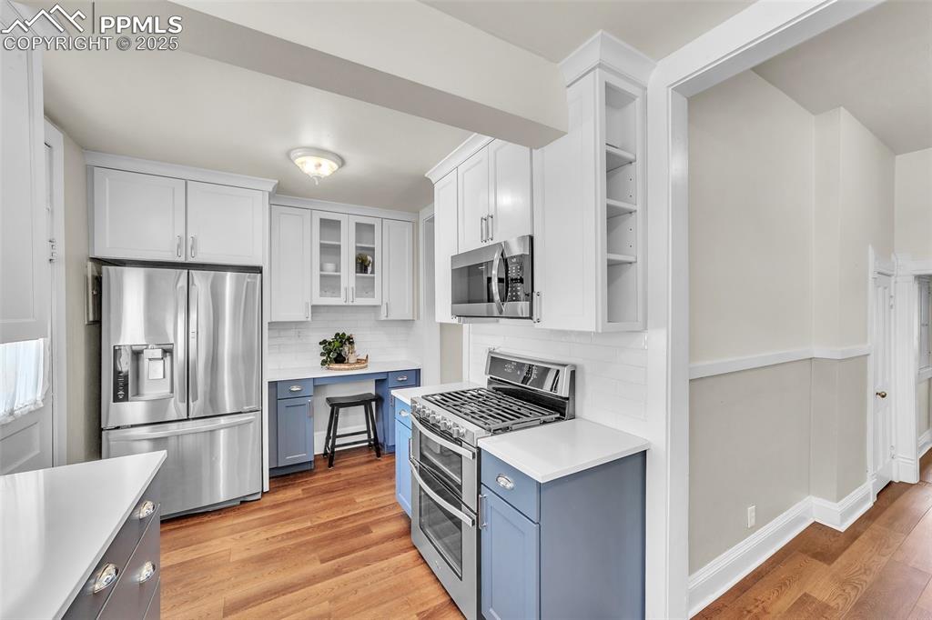 Image 11 of 49: Kitchen featuring appliances with stainless steel finishes, light counterto