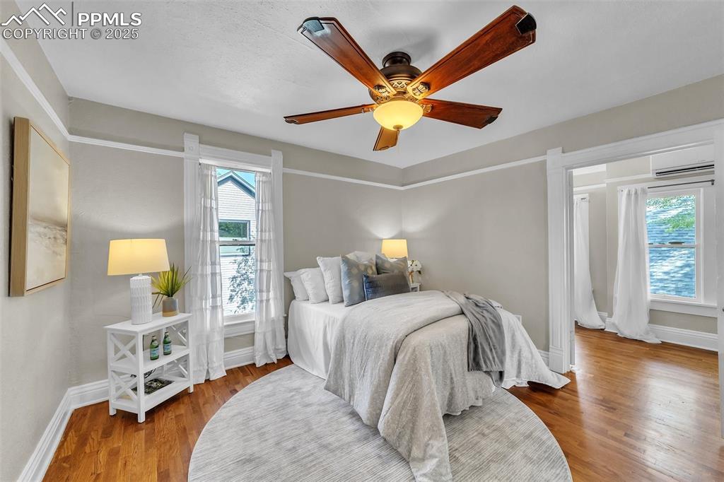 Image 24 of 49: Bedroom with wood finished floors, a wall mounted air conditioner, and ceil
