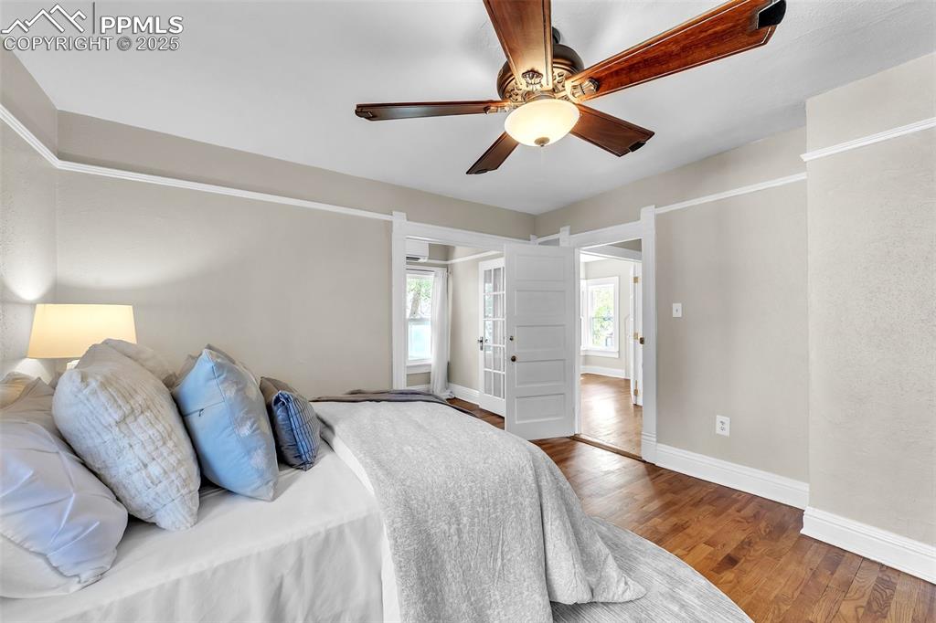 Image 25 of 49: Bedroom with wood finished floors and ceiling fan