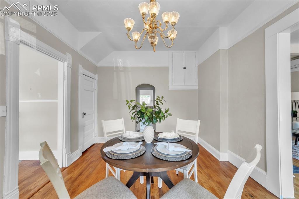Image 3 of 49: Dining room featuring original wood flooring and a chandelier