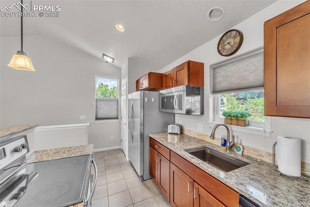 Image 32 of 49: Apartment: Kitchen featuring appliances with stainless steel finishes, vaul